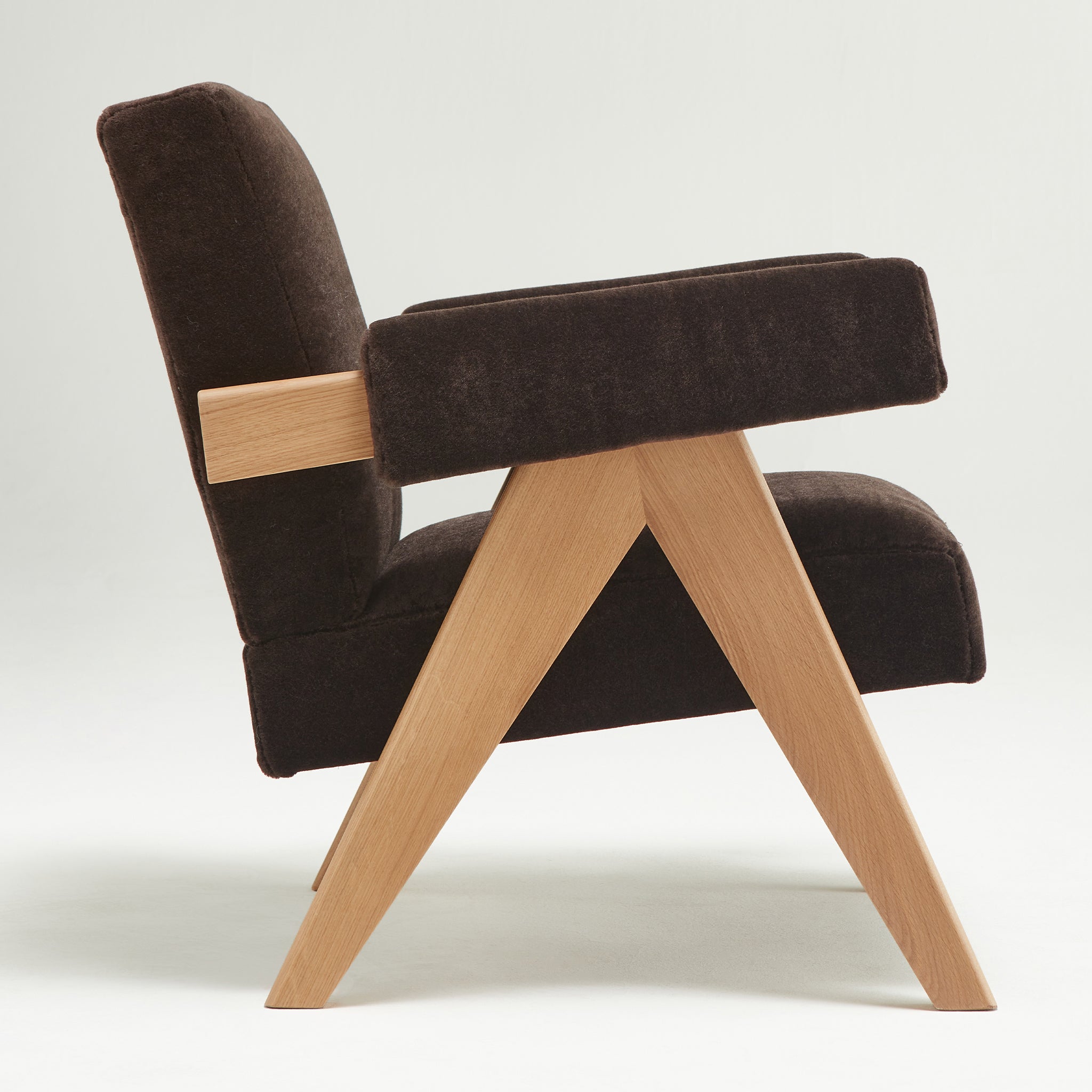 Side view of an authentic chandigarh lounge chair, pierre jeanneret era, natural oak frame, pierre frey choco teddy mohair upholstery, by Klarel #K35-31