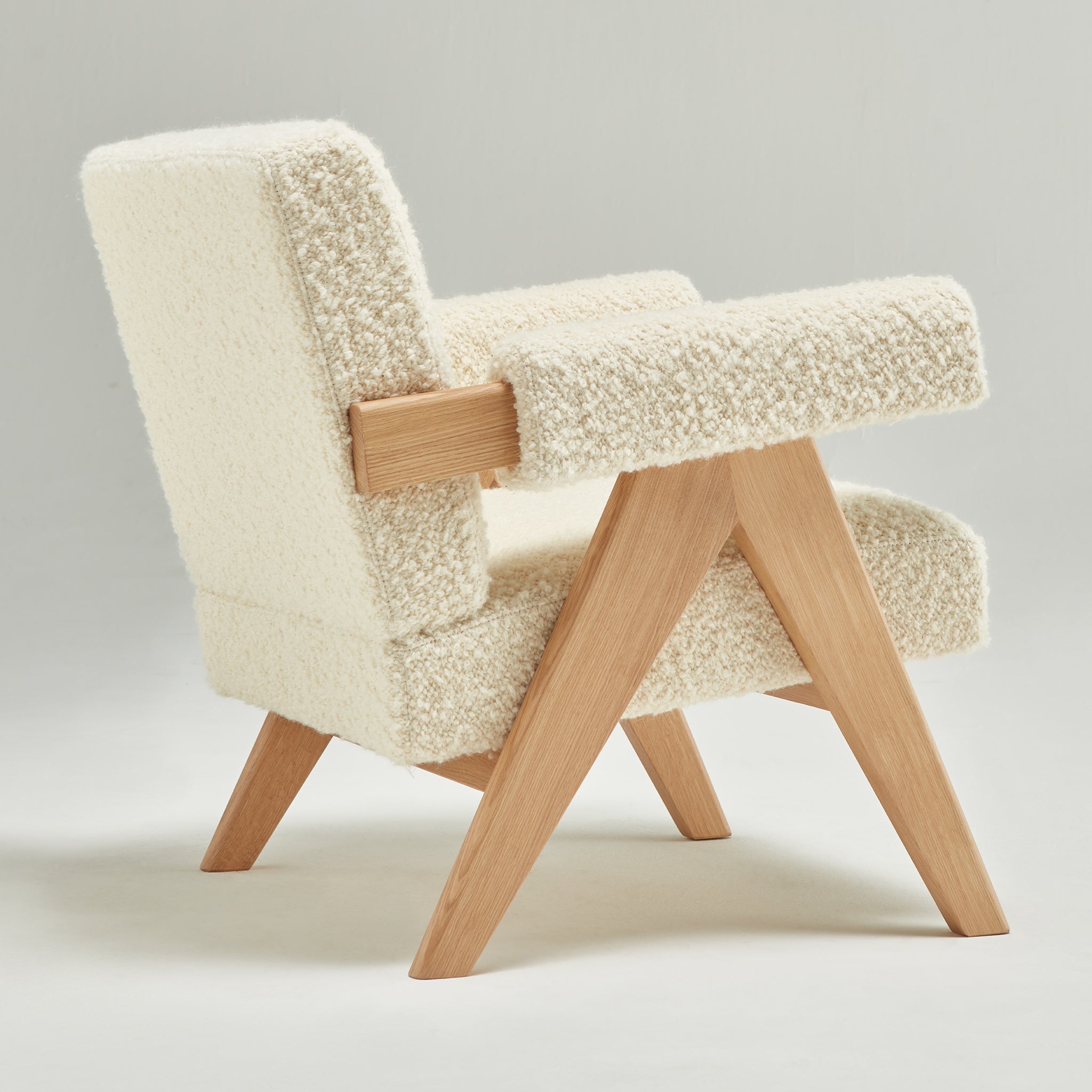 Back view of an authentic chandigarh lounge chair, pierre jeanneret era, natural oak frame, pierre frey opio naturel boucle upholstery, by Klarel #K35-33