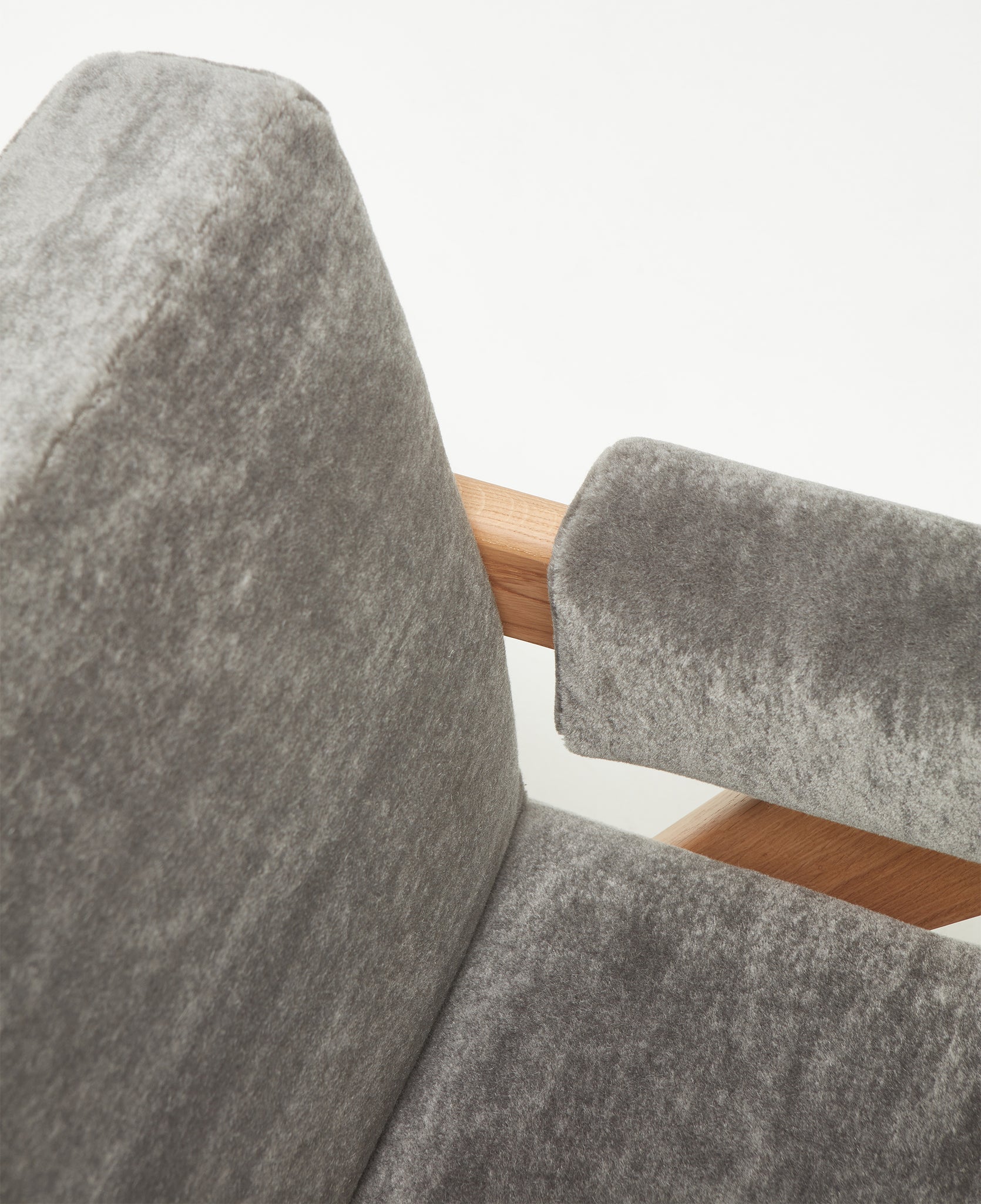 Close-up 1 of an authentic chandigarh lounge chair, pierre jeanneret era, natural oak frame, pierre frey elephant teddy mohair upholstery, by Klarel #K35-34