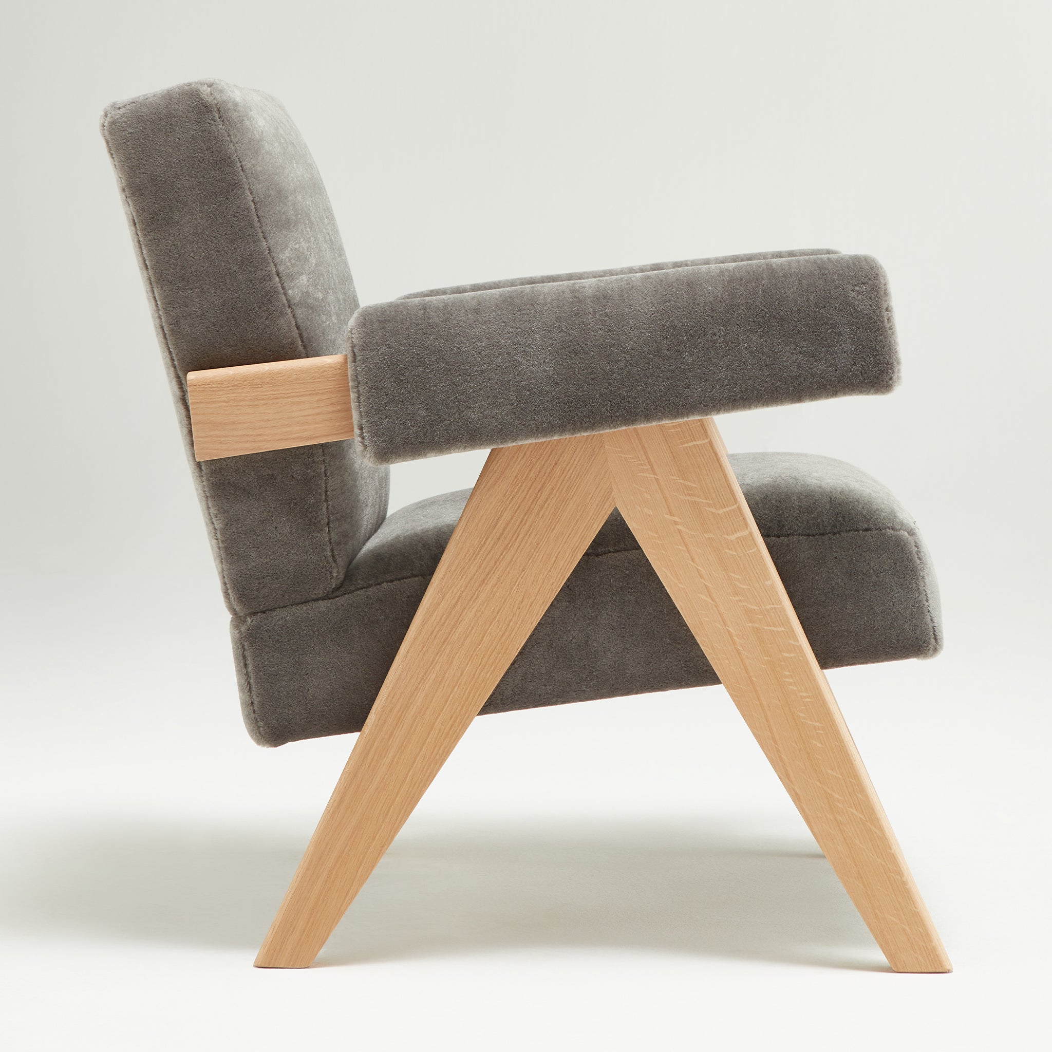 Side view of an authentic chandigarh lounge chair, pierre jeanneret era, natural oak frame, pierre frey elephant teddy mohair upholstery, by Klarel #K35-34