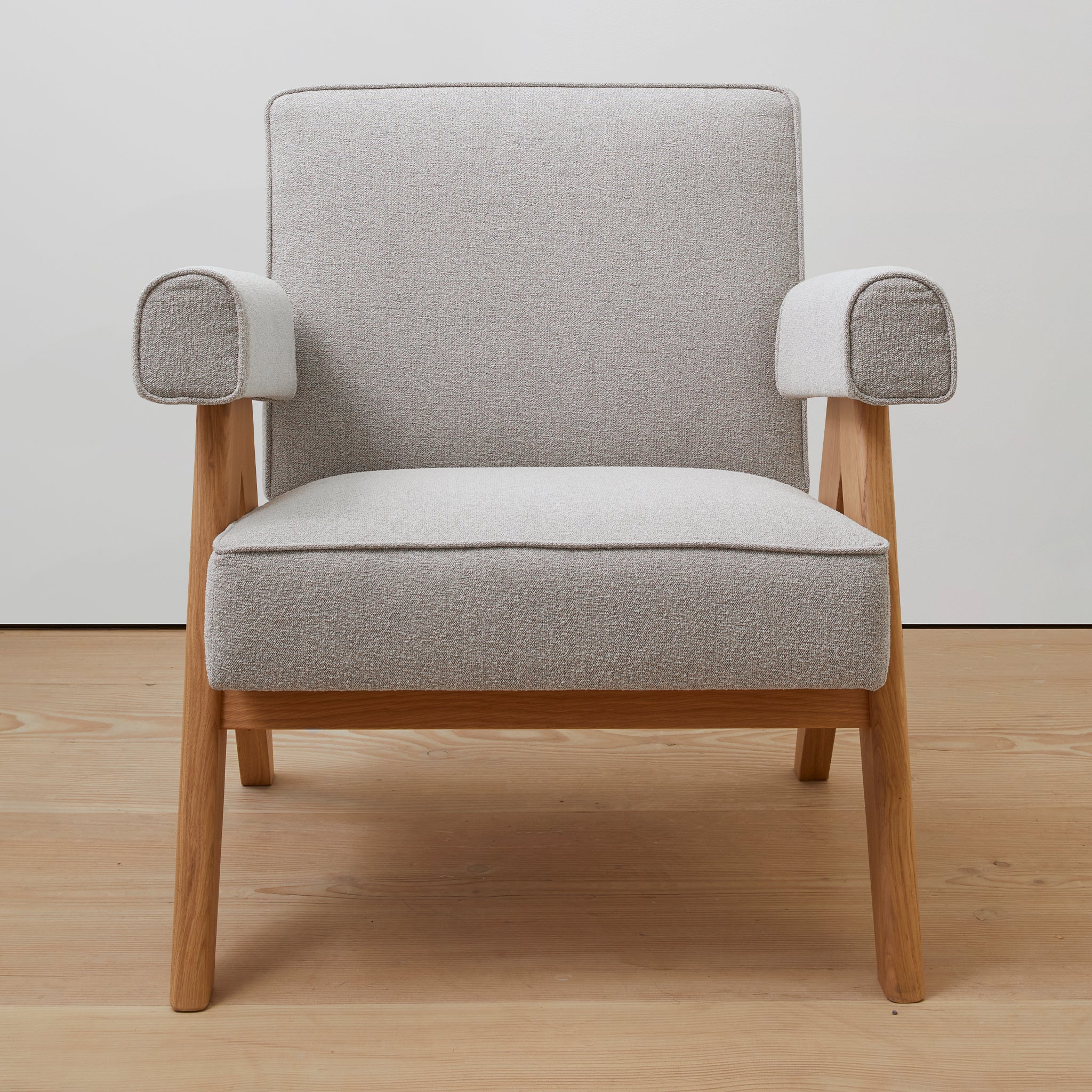 Front view of an authentic chandigarh lounge chair, pierre jeanneret era, natural oak frame, gray boucle upholstery, by Klarel #K35-37