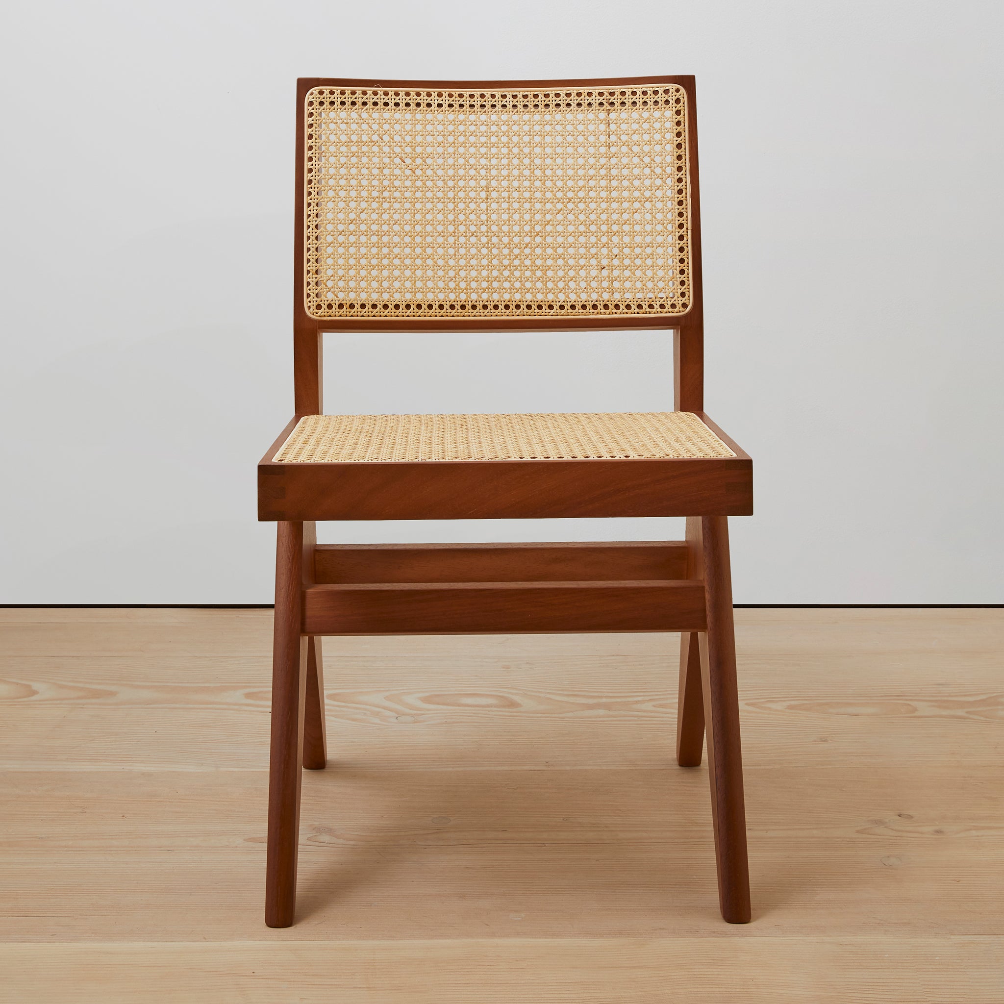 Front view of an authentic chandigarh side chair, pierre jeanneret era, teak frame, viennese cane, produced by Klarel. #K38-1